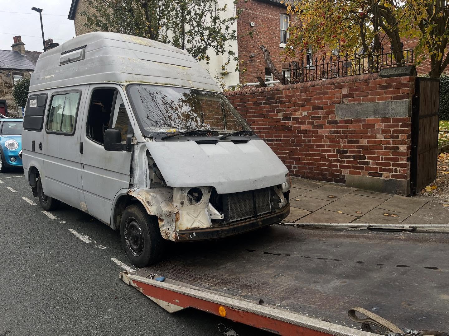 White Ford Transit van with a damaged front end parked on a Leeds street awaiting scrap collection